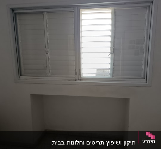 חלון עם תריסים סגורים בחדר